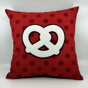 Coussin Bretzel, toile rouge et pois velours.